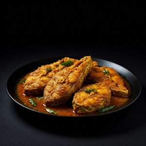 Fish kadhai with curry leaves served in a black dish on a dark surface.