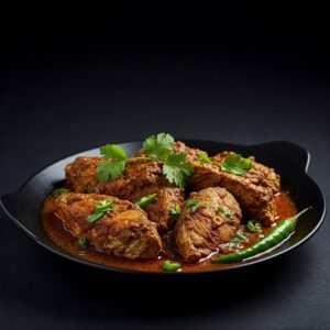 Fish masala garnished with cilantro and green chilies on a black plate.