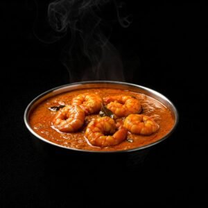 Prawn vindaloo with potatoes and green peppers in a metal bowl.
